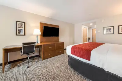 a hotel room with a bed and a desk with a computer at Comfort Inn Grove City - Columbus South in Grove City