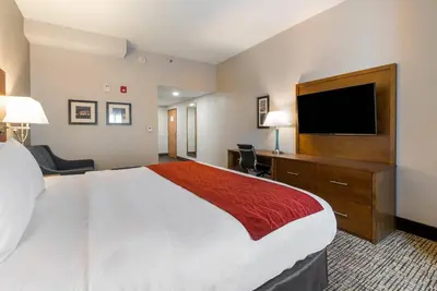 a hotel room with a large bed and a flat screen tv at Comfort Inn Grove City - Columbus South in Grove City