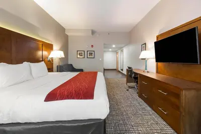 a hotel room with a bed and a flat screen tv at Comfort Inn Grove City - Columbus South in Grove City