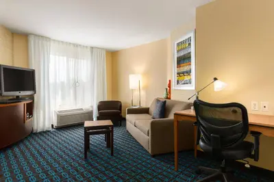 a hotel room with a couch and a desk at Fairfield Inn & Suites by Marriott Weirton in Weirton