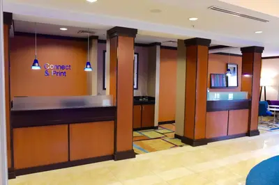 a lobby of a hotel with a bar in the middle at Fairfield Inn & Suites by Marriott Weirton in Weirton