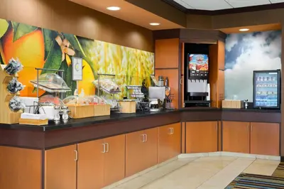 a restaurant with a counter with food on it at Fairfield Inn & Suites by Marriott Weirton in Weirton