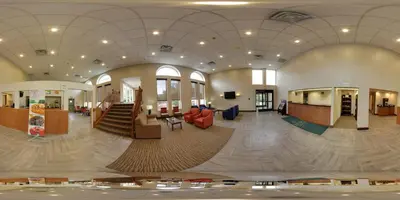 a large lobby with a staircase in a building at GreenRidge Hotel in Wickliffe