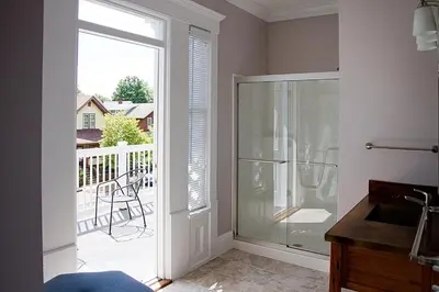 a bathroom with a glass shower and a balcony at Wishmaker House B&b in Bellville