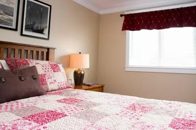 a bedroom with a bed with a pink quilt at Wishmaker House B&b in Bellville