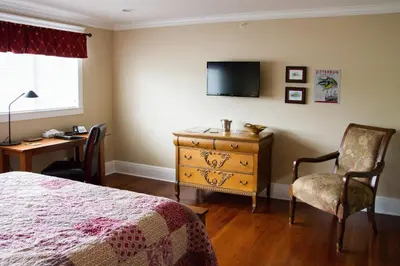 a bedroom with a bed and a desk and a tv at Wishmaker House B&b in Bellville