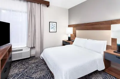 a hotel room with a bed and a flat screen tv at Candlewood Suites Columbus North - Worthington by IHG in Columbus