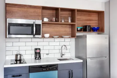 a kitchen with a stainless steel refrigerator and a microwave at Candlewood Suites Columbus North - Worthington by IHG in Columbus