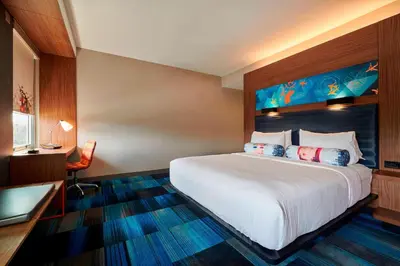 a hotel room with a bed and a desk at Aloft Cleveland Airport in North Olmsted