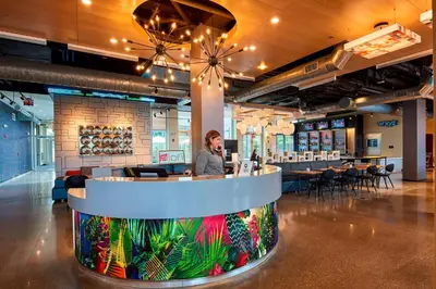 a man standing at a bar in a restaurant at Aloft Cleveland Airport in North Olmsted