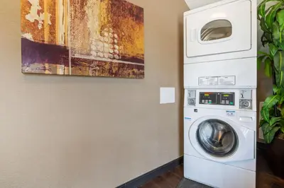 a washer and dryer in a room with a painting at Best Western Hilliard Inn & Suites in Hilliard