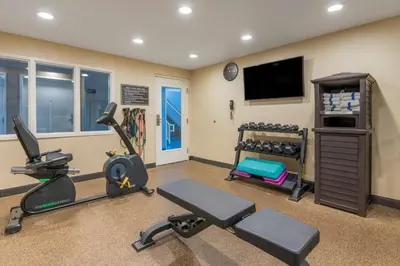 a gym with exercise equipment and a flat screen tv at Best Western Hilliard Inn & Suites in Hilliard