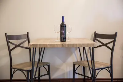 a table with a bottle of wine and two chairs at Landoll's Mohican Castle in Loudonville