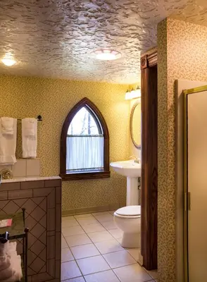 a bathroom with a toilet and a sink and a window at Landoll's Mohican Castle in Loudonville