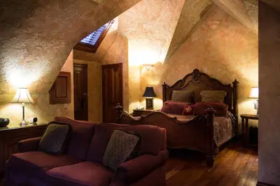a bedroom with a bed and a couch in a room at Landoll's Mohican Castle in Loudonville