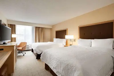 a hotel room with two beds and a flat screen tv at Hampton Inn & Suites Cleveland-Independence in Independence