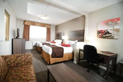 a hotel room with two beds and a desk at Best Western Plus Sandusky Hotel & Suites in Sandusky