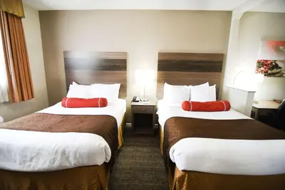 a hotel room with two beds with red pillows at Best Western Plus Sandusky Hotel & Suites in Sandusky