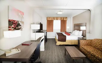 a hotel room with a bed and a couch at Best Western Plus Sandusky Hotel & Suites in Sandusky