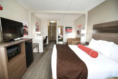 a hotel room with a bed and a flat screen tv at Best Western Plus Sandusky Hotel & Suites in Sandusky