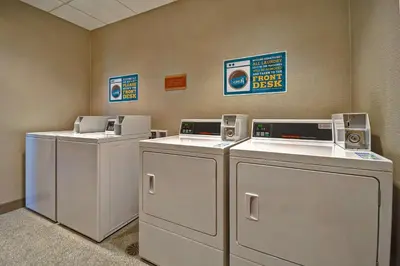 a row of washers and dryers in a room at Home2 Suites By Hilton Bowling Green, Oh in Bowling Green