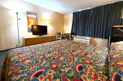 a hotel room with a bed with a colorful blanket at Red Carpet Inn & Suites Lima -Listing Partner in Lima