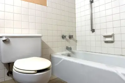 a bathroom with a toilet and a bath tub and a white toilet at Red Carpet Inn & Suites Lima -Listing Partner in Lima