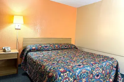 a hotel room with a bed and a telephone at Red Carpet Inn & Suites Lima -Listing Partner in Lima