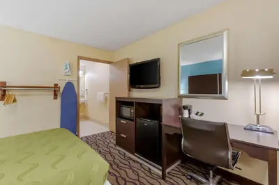 a hotel room with a desk and a television at Quality Inn Columbus-East in Columbus