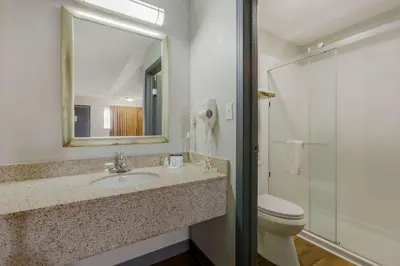 a bathroom with a sink and a toilet and a mirror at Quality Inn Columbus-East in Columbus