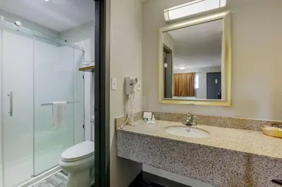 a bathroom with a sink and a toilet and a mirror at Quality Inn Columbus-East in Columbus