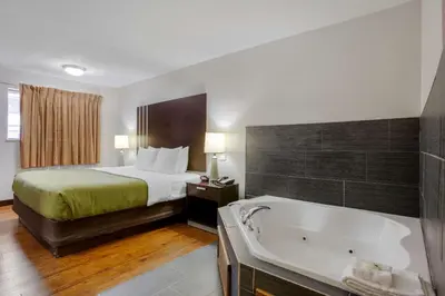 a hotel room with a bed and a bath tub at Quality Inn Columbus-East in Columbus