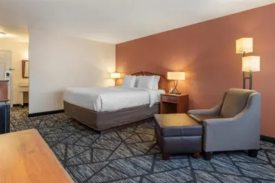a hotel room with a bed and a chair at SureStay Plus Hotel by Best Western Auburn in Auburn