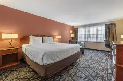 a hotel room with a bed and a large window at SureStay Plus Hotel by Best Western Auburn in Auburn