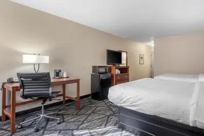 a hotel room with a bed and a desk with a computer at SureStay Plus Hotel by Best Western Auburn in Auburn