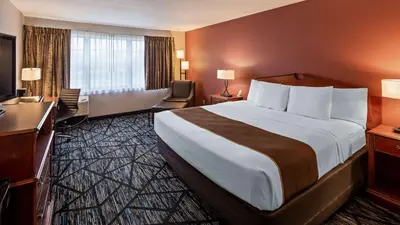 a hotel room with a large bed and a desk at SureStay Plus Hotel by Best Western Auburn in Auburn