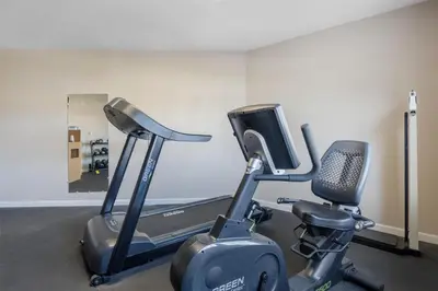 a gym with a treadmill and a exercise bike at SureStay Plus Hotel by Best Western Auburn in Auburn