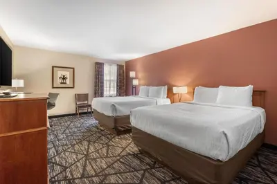 a hotel room with two beds and a television at SureStay Plus Hotel by Best Western Auburn in Auburn