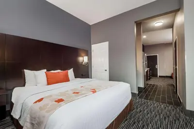 a bedroom with a large white bed with orange pillows at Hawthorn Extended Stay by Wyndham Columbus West in Columbus