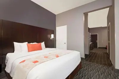 a bedroom with a large white bed with orange pillows at Hawthorn Extended Stay by Wyndham Columbus West in Columbus