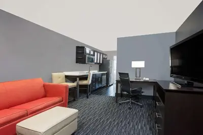a living room with a couch and a table with a tv at Hawthorn Extended Stay by Wyndham Columbus West in Columbus