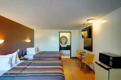 a hotel room with a bed and a desk at Americas Best Value Inn Heath-Newark in Heath