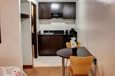 a small kitchen with a small table and chairs at Americas Best Value Inn Heath-Newark in Heath