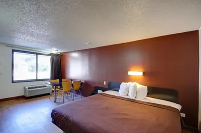 a hotel room with a bed and a table and chairs at Americas Best Value Inn Heath-Newark in Heath
