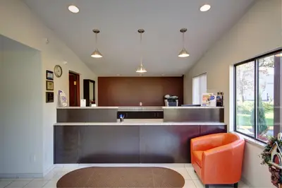 a kitchen with an orange chair and a counter at Americas Best Value Inn Heath-Newark in Heath