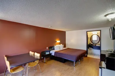 a hotel room with a bed and a dining table at Americas Best Value Inn Heath-Newark in Heath