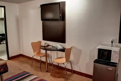 a room with a table and two chairs and a tv at Americas Best Value Inn Heath-Newark in Heath