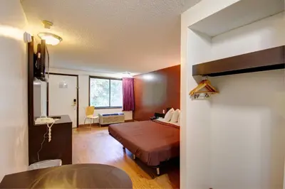 a bedroom with a bed and a desk and a window at Americas Best Value Inn Heath-Newark in Heath