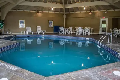 a large swimming pool with chairs and tables at Baymont by Wyndham Youngstown in Youngstown