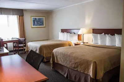 a hotel room with two beds and a table at Baymont by Wyndham Youngstown in Youngstown